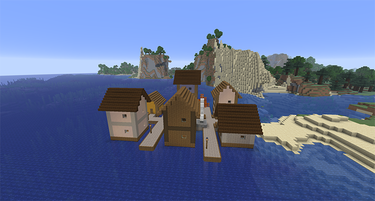 Town of wooden houses on walkways over the ocean with a small plaza and an anchor statue