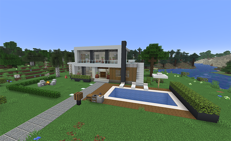 Simple modern Minecraft house with white concrete walls, a glass upper floor that hangs over the entrance, outside stairs to a roof terrace, a pool, and a fire pit on the lawn