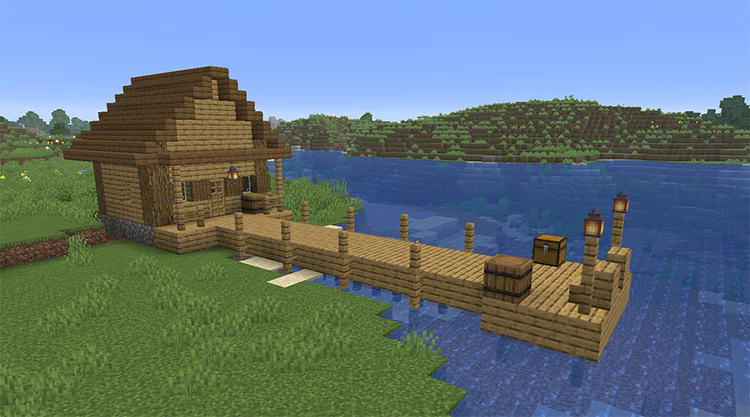 Simple oak dock on fence posts leading from a small wooden cabin into the water