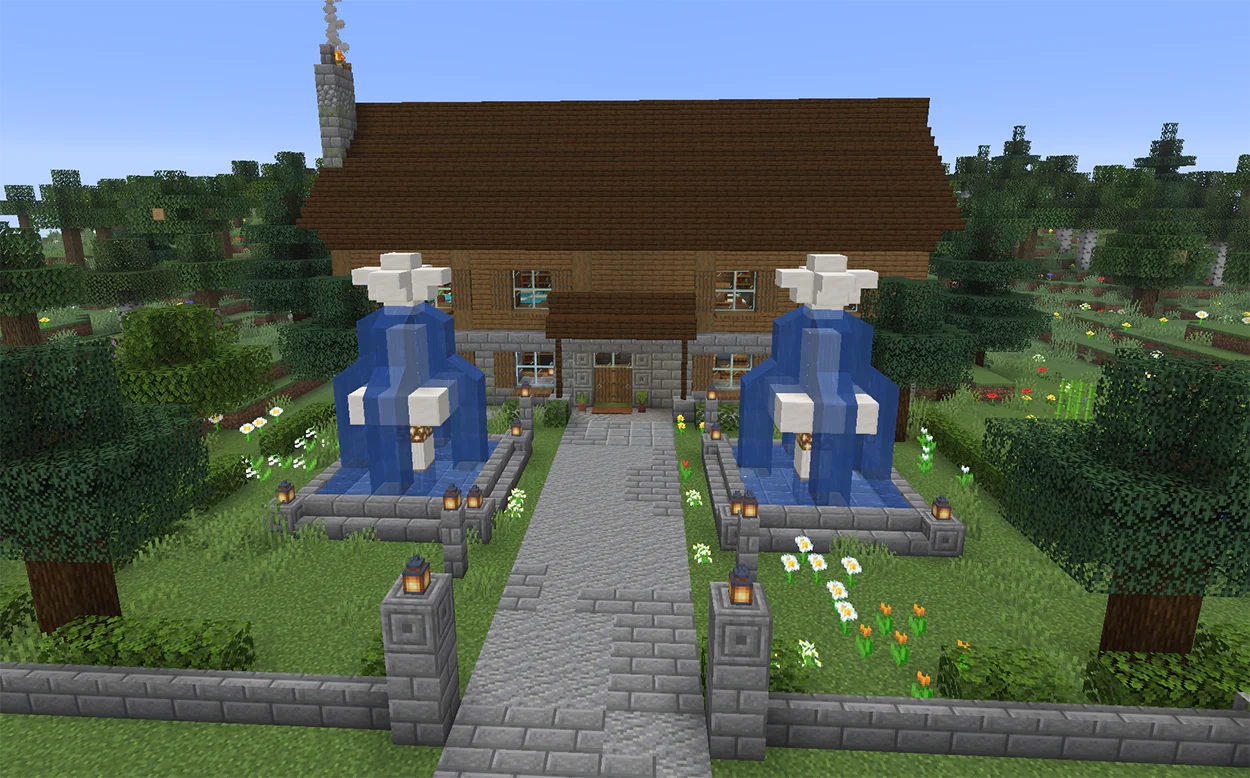 Two tall quartz fountains in front of a Minecraft house entrance